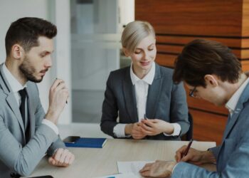 Business people signing a contract at a table.