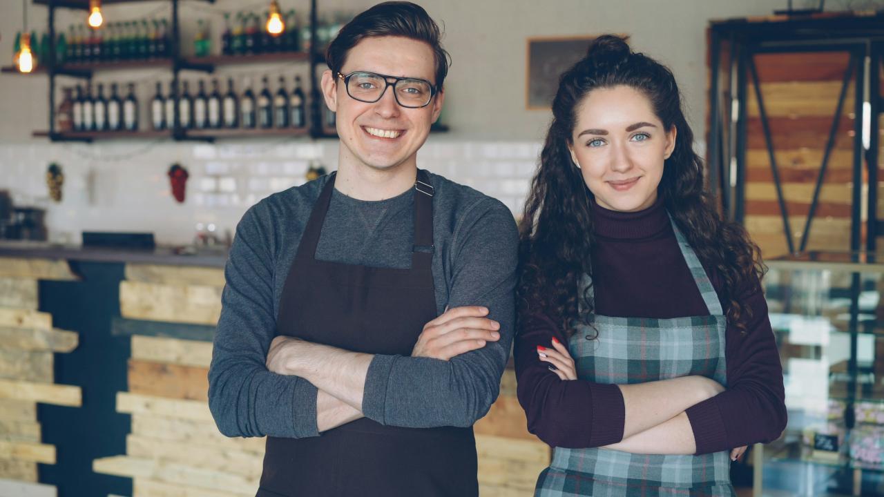 Dua pemilik kafe dengan bangga berdiri bersama.